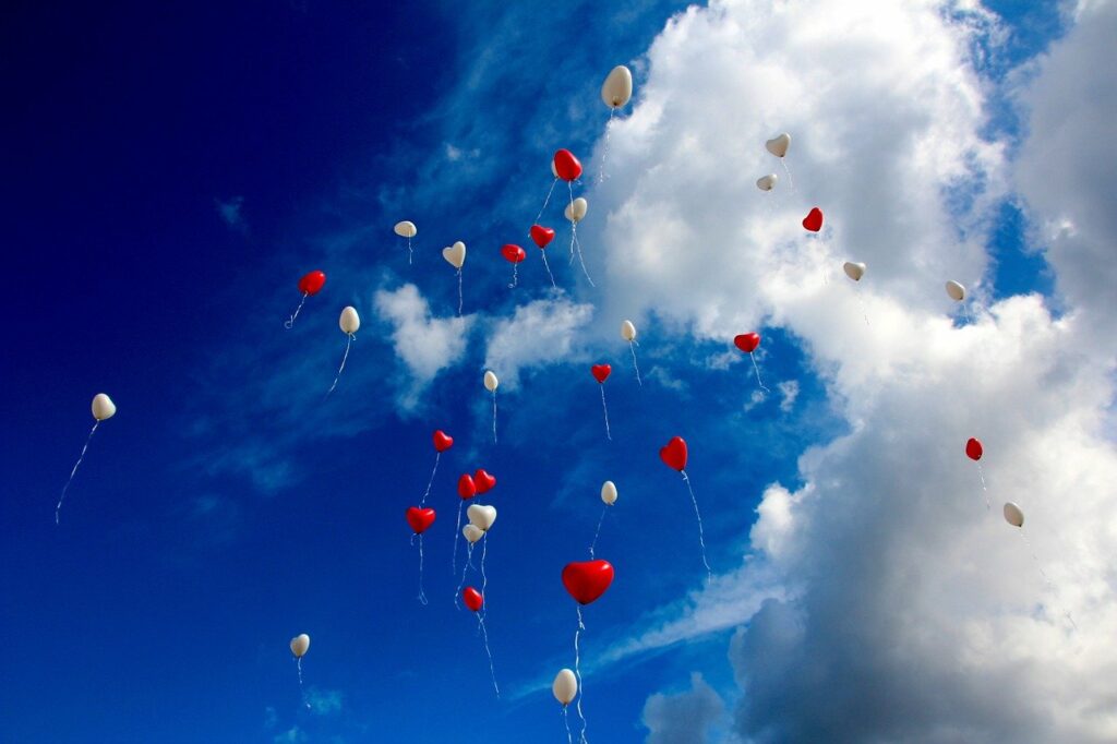 Herzsymbole und Liebe Ballons fliegen zum Himmel