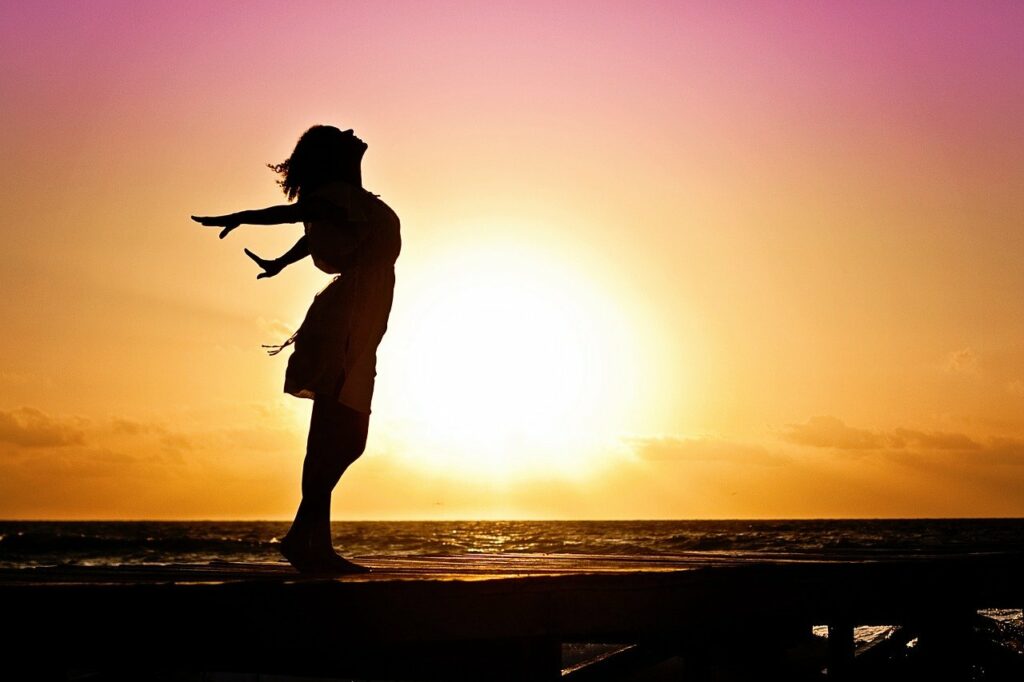 Frau glücklich frei Sonnenuntergang göttliche Weiblichkeit erwecken