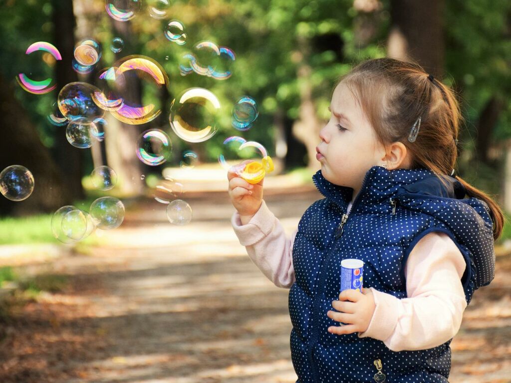 Mädchen spielt mit Seifenblasen Wie kümmert man sich um ein sensibles Kind