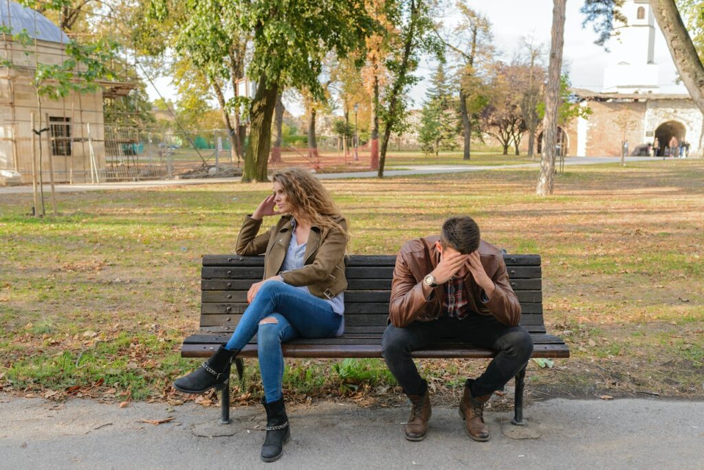 Streit Beziehungsprobleme Paar sitzt auf Parkbank Giftige Beziehungen erkennen Toxische Partnerschaften