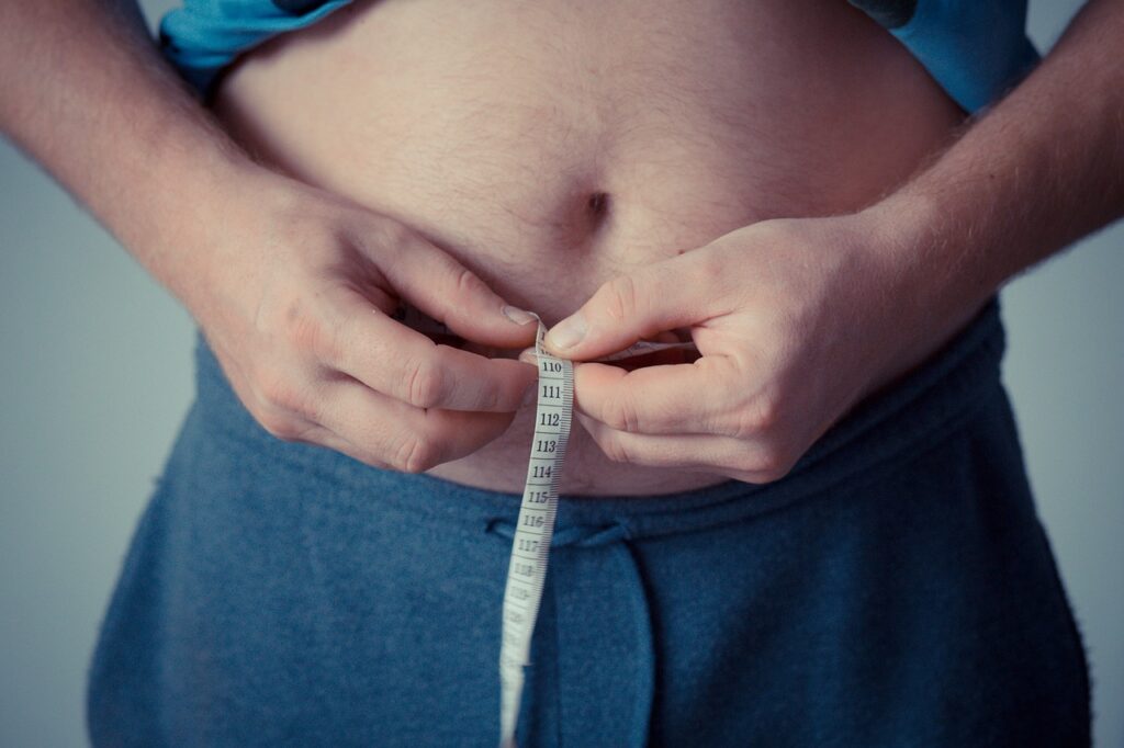 Mann misst seinen Bauchumfang Die Wahrheit über Gewichtsverlust Kann Hypnose wirklich beim Abnehmen helfen